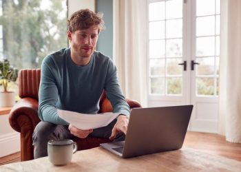 1 Man Sitting On Armchair At Home With Laptop Paying Bill Online – TodayHeadline