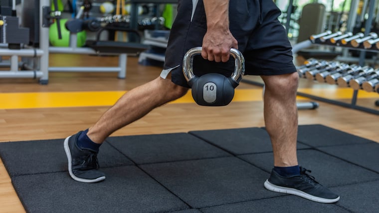 Close-up of lower body performing kettlebell leg exercise