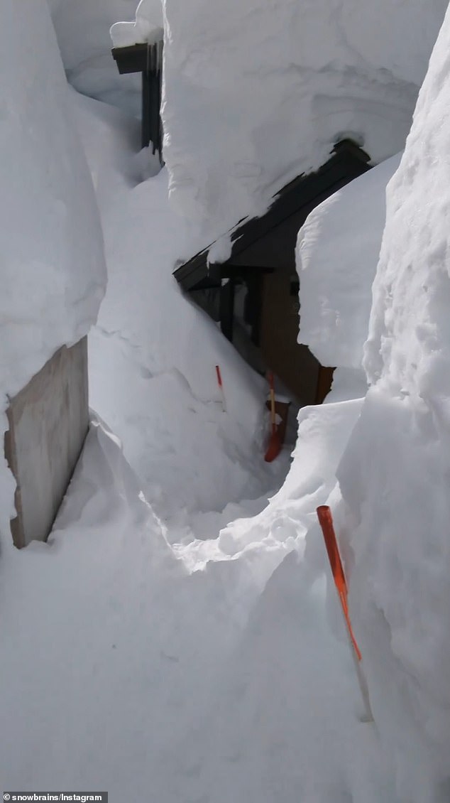 The house has huge snowbanks lining the front walk, nearly twice as tall as Clark standing at eight to 10 feet that loom all the way to the front door, where densely packed snow hangs overhead. The only part of the home that was visible is the door and front wall, as the sides of the home and the roof are covered in feet of snow