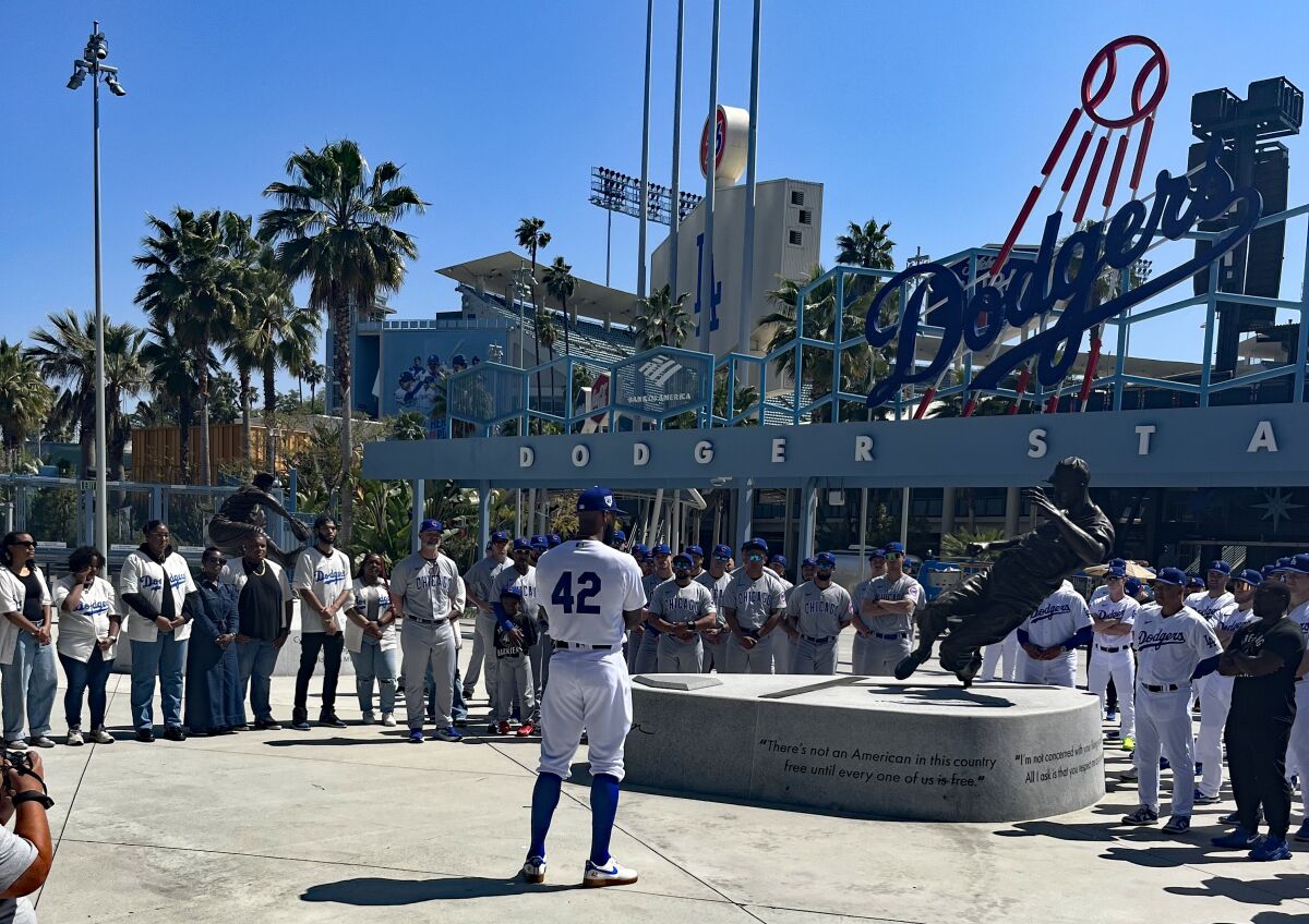 Dodgers outfielder Jason Heyward speaks to players and community leaders in front of the Jackie Robinson statue.