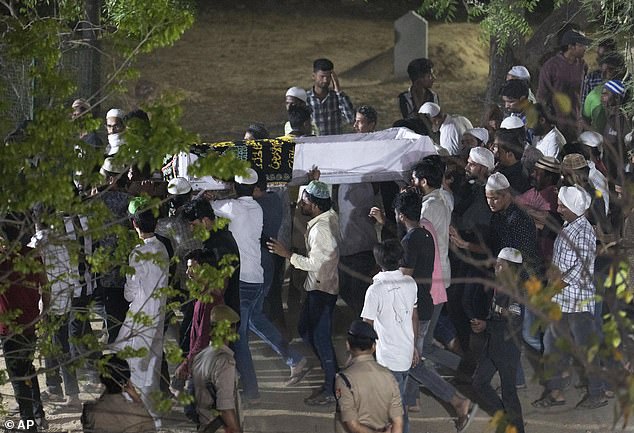Relatives and locals carry the body of Atiq Ahmad, a former Indian lawmaker convicted of kidnapping and facing murder and assault charges, for burial in Prayagraj, India, on Sunday