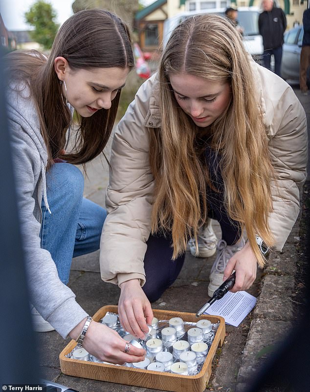 Maddie's Sister Amelie, 18, lights a candle with her friend during a 16th anniversary vigil marking her older sibling's disappearance