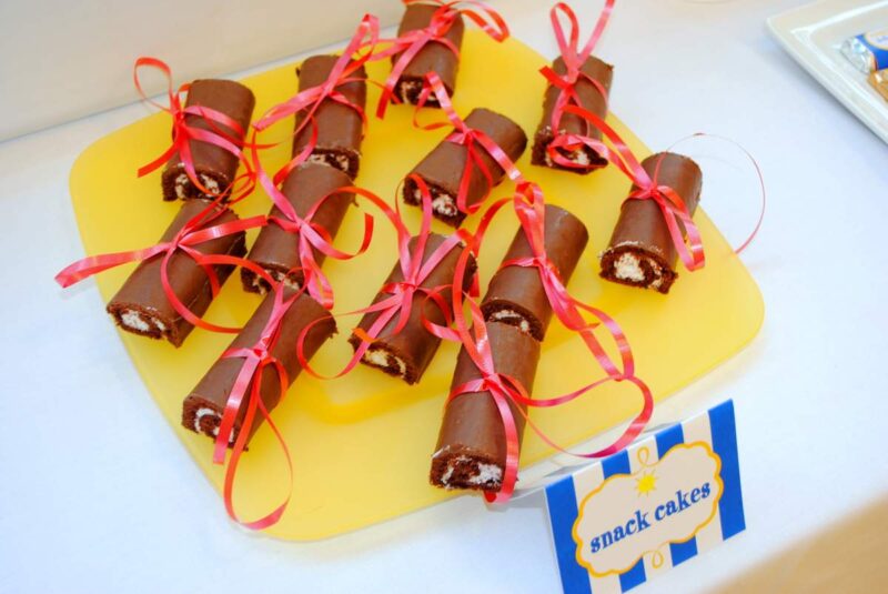 Preschool graduation ideas include chocholate treats wrapped with red ribbon to look like diplomas.