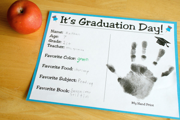 A certificate has a child's handprint on it and says It's Graduation Day!