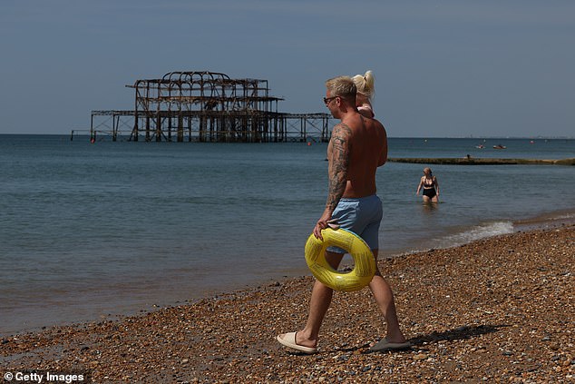BRIGHTON: A dad took his little girl for a dip in the sea as the southeast welcomed warm weather