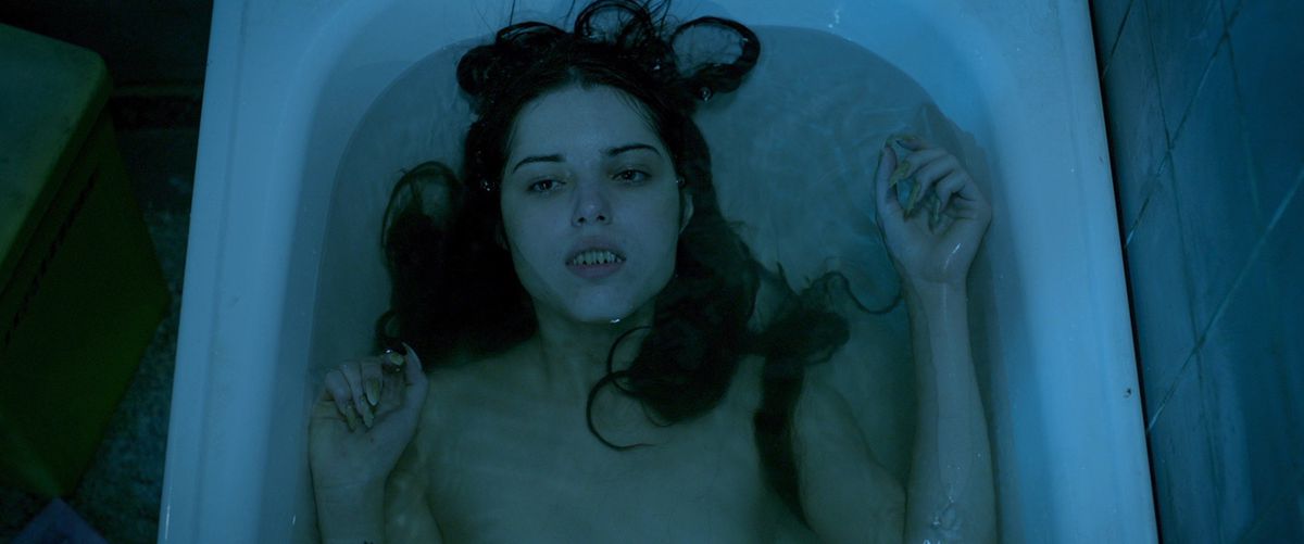 a beautiful razor-toothed mermaid lays back in a tub