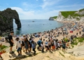 Hundreds of sunseekers flocked to Durdle Door in Dorset today to make the most of the scorching hot sunshine as temperatures rose to 23C