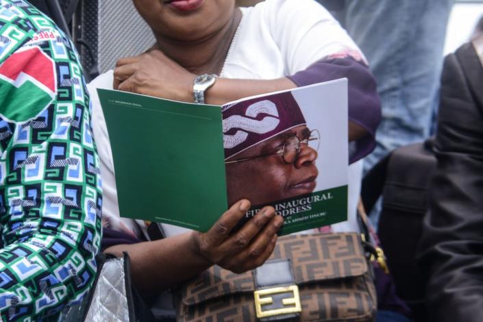 A woman looks at an official booklet showing the face of Bola Tinubu at his inauguration ceremony in Abuja, Nigeria - Monday 29 May 2023