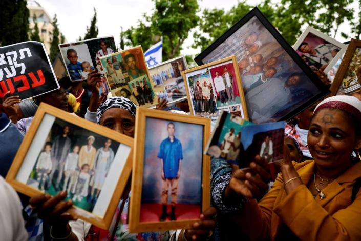 Israelis of Ethiopian descent hold up pictures of their relatives during a protest calling on the Israeli government to stop a freeze on Jewish Ethiopian immigration to Israel, outside the weekly cabinet meeting in Jerusalem, Israel - Sunday 28 May 2023