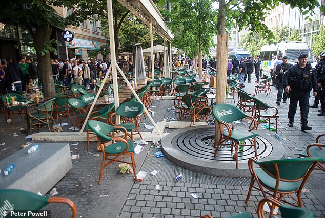 Pictured: tables and chairs are seen scattered at a bar where Fiorentina ultras ran through