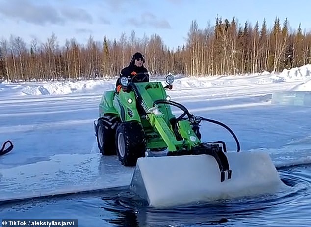 Colleague Rami Kurtakko is seen using a wheel loader to lift ice cubes out of the river, which are then cleaned and stored for use the following autumn