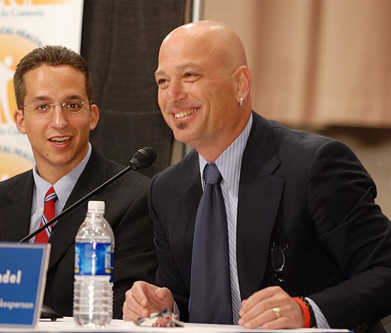 Howie Mandel sitting at a table and speaking on a panel