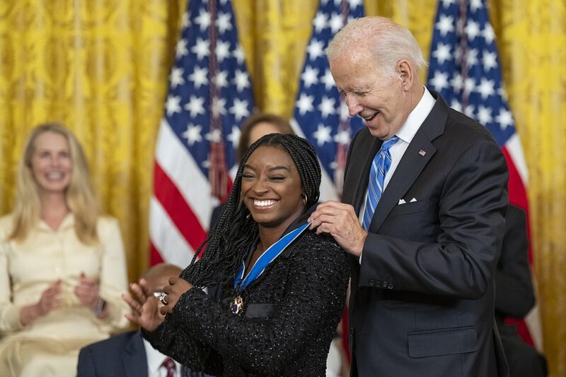 Simone Biles receiving a medal from President Joe Biden