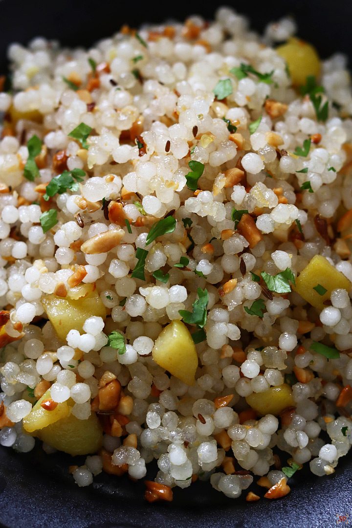 sabudana khichdi served in a black plate with handles on both the sides