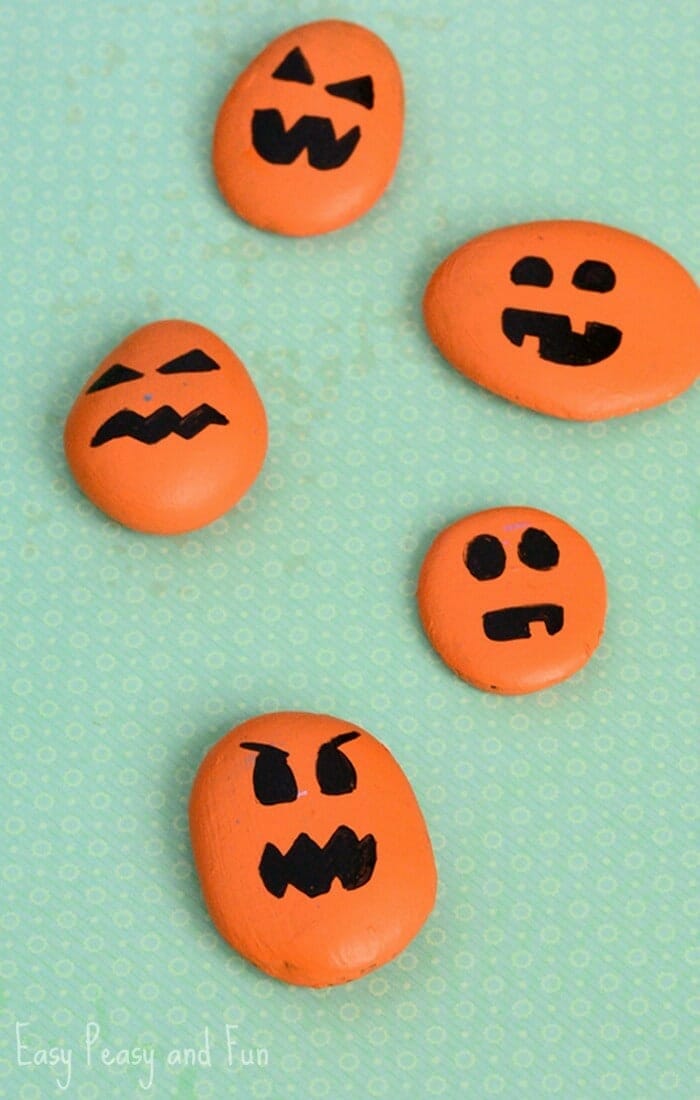 Several rocks are painted orange with black jack o' lantern faces painted on them (Halloween Activities)