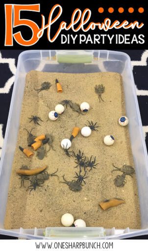 A plastic container is filled with sand and witches fingers, spiders, and eyeballs (Halloween Activities)