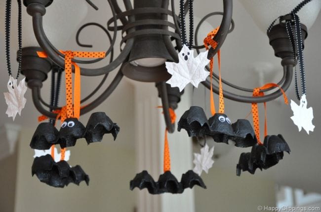 Leaves painted to look like ghosts and bats made of egg cartons hanging from a chandelier (Halloween Activities)