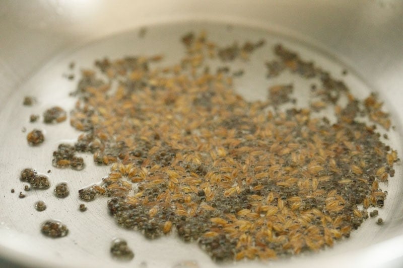 cumin seeds added to hot oil for making tempering mixture for appe. 