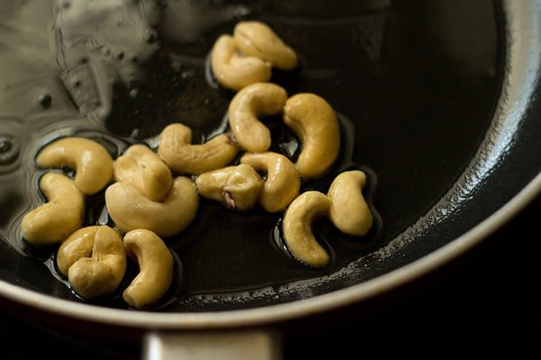 frying cashewnuts in pan.