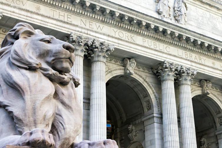 A statue of a lion outside the grand entrance to the New York Public Library