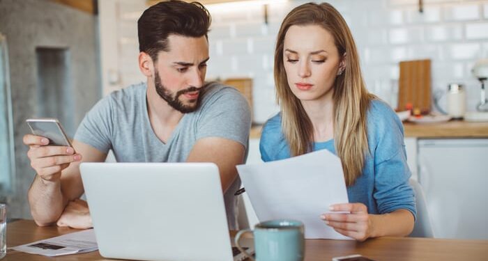 Couple reviewing finances in kitchen.