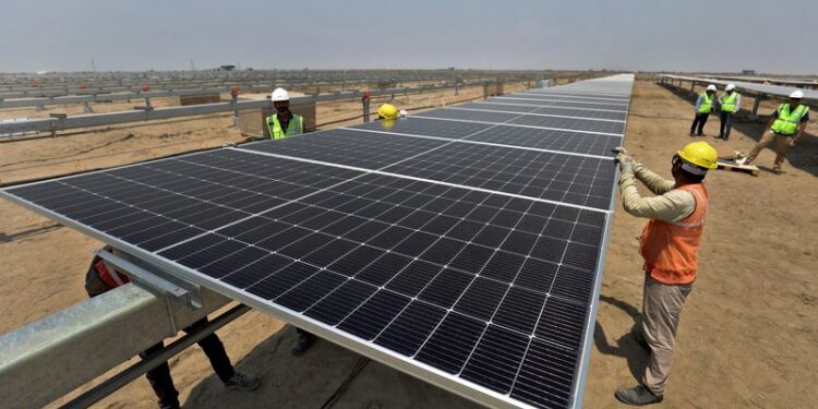 © Reuters. FILE PHOTO: Workers install solar panels at the Khavda Renewable Energy Park of Adani Green Energy Ltd (AGEL) in Khavda, India, April 12, 2024.REUTERS/Amit Dave/File Photo