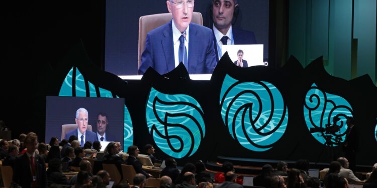 COP29 President Mukhtar Babayev projected onto a screen, with audience in foreground