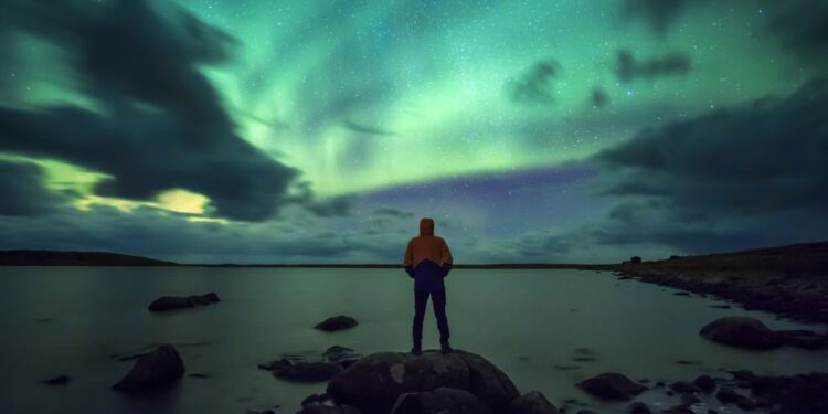 person looking at northern lights