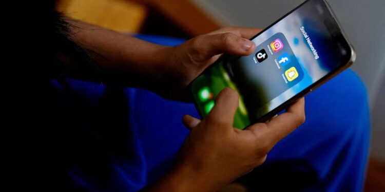 © Reuters. A high school student poses with her mobile showing her social media applications in Melbourne, Australia, November 28, 2024. REUTERS/Asanka Brendon Ratnayake/File Photo