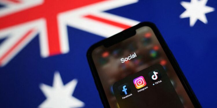 © Reuters. Facebook, Instagram and TikTok apps are seen on a smartphone in front of an Australian flag, in this illustration taken November 29, 2024. REUTERS/Edgar Su/Illustration