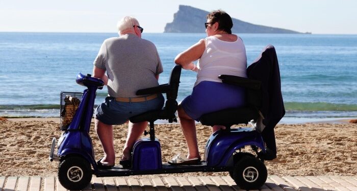 Elderly British tourists relaxing on the beach in Spain