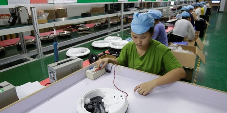 © Reuters. FILE PHOTO: An employee works on the production line of a robot vacuum cleaner factory of Matsutek in Shenzhen, China August 9, 2019. REUTERS/Jason Lee/File Photo