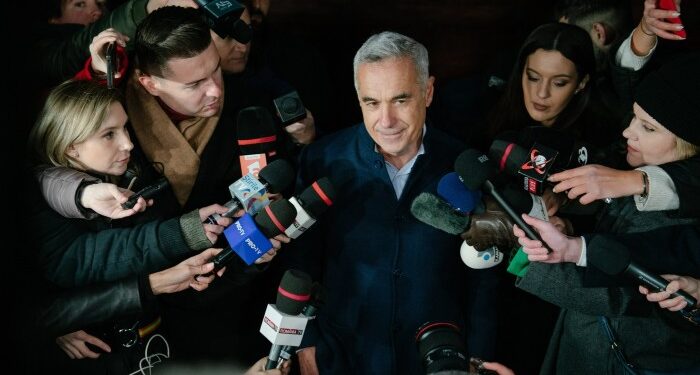 Călin Georgescu, centre, giving a statement while journalists hold microphones in front of him on the outskirts of Bucharest, Romania on November 26 2024