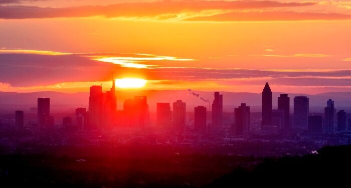 The sun rises behind the buildings of the banking district in Frankfurt, Germany