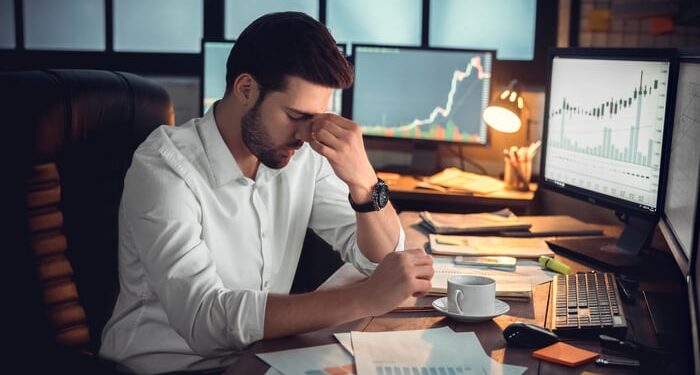 Frustrated investor looking at computer screens