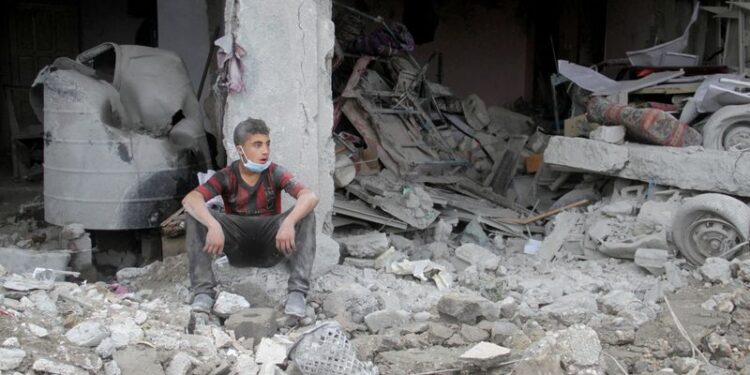 © Reuters. A Palestinian boy sits amidst rubble at the site of an Israeli strike on a house, amid the ongoing conflict between Israel and Hamas, in Gaza City November 26, 2024. REUTERS/Mahmoud Issa