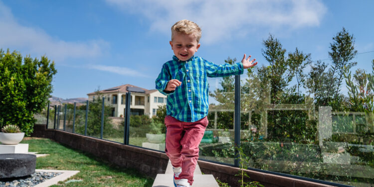 A photo of a toddler running in his backyard.