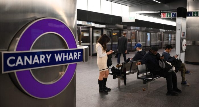 Commuters wait at the newly opened Canary Wharf Elizabeth Line station