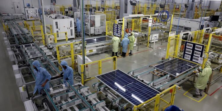 © Reuters. FILE PHOTO: Workers assemble Photovoltaic Modules at the plant of Adani Green Energy Ltd (AGEL) in Mundra, India, April 11, 2024. REUTERS/Amit Dave/File Photo