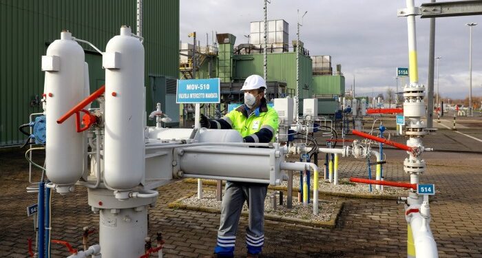 An employee inspects shut-off valves during routine maintenance at the Messina compressor station, operated by Snam in Gallese, Italy