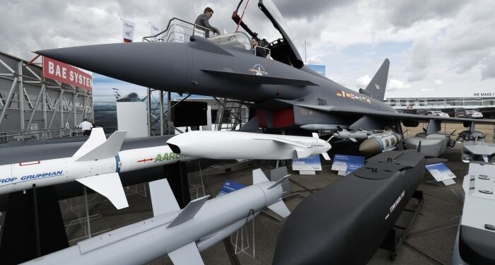 A man sits in the cockpit of a Eurofighter Typhoon aircraft at the BAE Systems exhibition space during the Farnborough Airshow in England