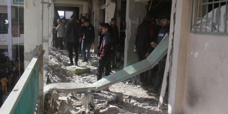 © Reuters. Palestinians walk amid the rubble, inspecting the damage, following an Israeli strike on a school sheltering displaced people, amid the Israel-Hamas conflict, in Gaza City December 14, 2024. REUTERS/Mahmoud Issa