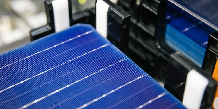 Close-up image of a deep blue solar panel with silver horizonal lines on it, on black equipment