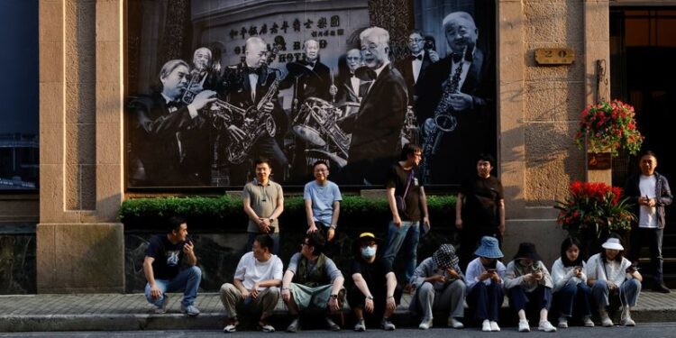 © Reuters. FILE PHOTO: People rest on a street in Shanghai, China May 24, 2021. REUTERS/Aly Song/File Photo