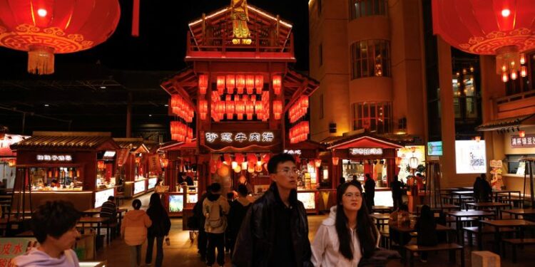 © Reuters. FILE PHOTO: People walk at a night market, during an organised media tour to Dunhuang, Gansu province, China October 15, 2024. REUTERS/Tingshu Wang/File Photo