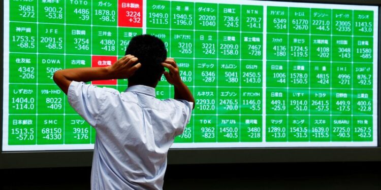 © Reuters. FILE PHOTO: A man looks at an electronic stock quotation board outside a brokerage in Tokyo, Japan August 2, 2024. REUTERS/Issei Kato/File Photo