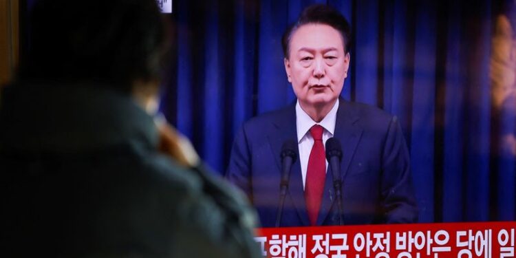 © Reuters. FILE PHOTO: A person watches the broadcasting of South Korean President Yoon Suk Yeol delivering an address to the nation, at a railway station in Seoul, South Korea, December 7, 2024. REUTERS/Kim Soo-hyeon/File Photo