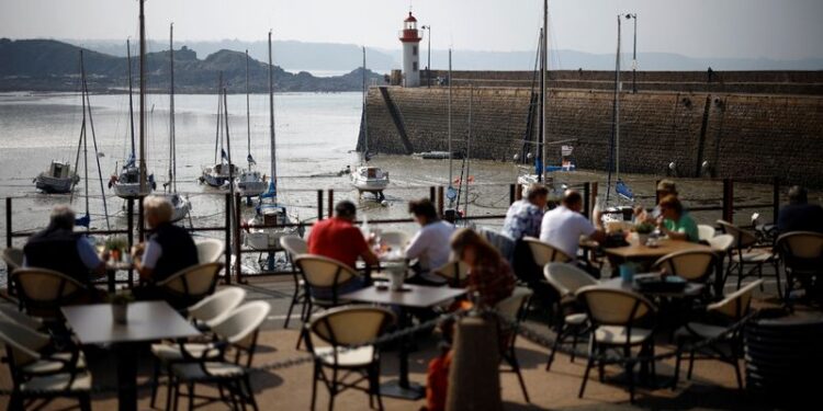 © Reuters. FILE PHOTO: People sit on the terrace of a restaurant in front of the harbour of Erquy, Brittany, France, September 19, 2024. REUTERS/Stephane Mahe/File Photo