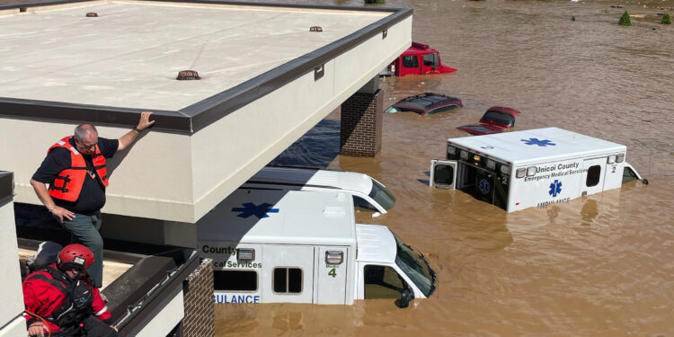 A photo of brown flood waters swallowing up ambulances.