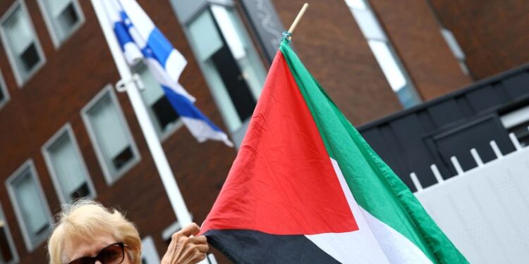 © Reuters. FILE PHOTO: A demonstrator in support of Palestinians holds the Palestinian flag outside the Israeli embassy after Ireland has announced it will recognise a Palestinian state, in Dublin, Ireland, May 22, 2024. REUTERS/Molly Darlington/File Photo